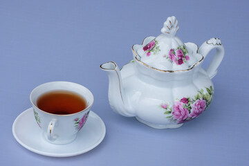 white flower teapot and hot cup and tea