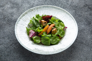 Hearty salad with wild mushrooms, baked potatoes, spinach sauce. Diet food. Ready menu for the restaurant. Neutral gray blue textured background