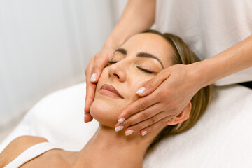 Fototapeta na wymiar Middle-aged woman having a head massage in a beauty salon.