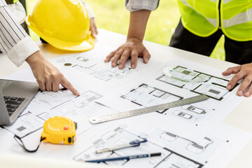 Two architect-engineers are consulting to modify the blueprints of the contracted house, they have a meeting to inspect the house designs before meeting with the client. Home design ideas.