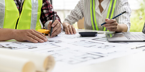 Two architect-engineers are consulting to modify the blueprints of the contracted house, they have a meeting to inspect the house designs before meeting with the client. Home design ideas.