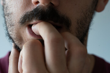 Naklejka premium Extreme close up of young man biting his nails