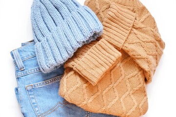 Fototapeta na wymiar Flat lay fall and winter women's outfit, clothes set. Brown woolen sweater, knitted hat and jeans top view photo