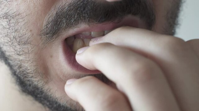Extreme close up of young man biting his nails