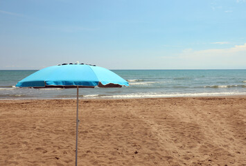 umbrella on the beach of blue color and no person symbol of relaxation