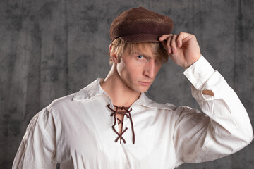 A young attractive man in a vintage retro outfit, a brown leather cap