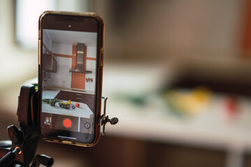 Verduras de colores en encimera de cocina  junto a un smartphone para subir contenido a redes...