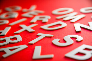 Mixed letters pile close up view photo. Red background