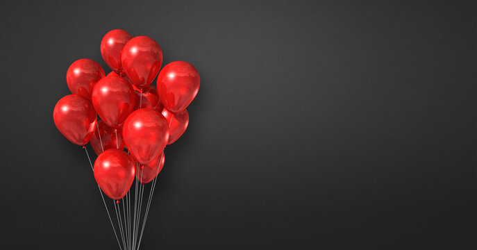 Red balloons bunch on a black wall background. Horizontal banner.