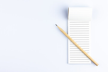 notebook and pencil on white background