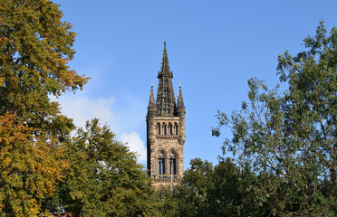 Fototapeta na wymiar Old Gothic Stone Tower & Spire seen against Blue Sky 