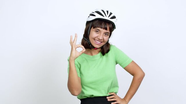Young woman with bike helmet over isolated background showing ok sign with fingers over isolated background