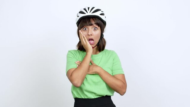 Young woman with bike helmet over isolated background gaping because have just surprised with a gift over isolated background