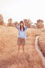 Teenage girl shows a rock sign. Meadow in the countryside.