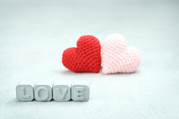 Fototapeta premium Word Love made of gray concrete letters. Two crochet heart. Valentine's Day.