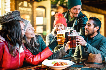 Happy multicultural friends drinking beer with nachos outdoors at night - Food and beverage lifestyle concept on young people enjoying time together outside