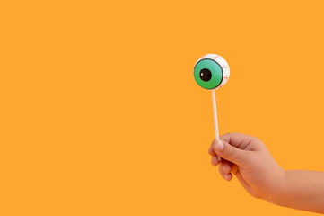 Halloween concept with human doll eyeball as lollipop