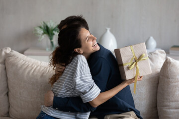 Happy young 30s latina woman embracing loving husband, feeling thankful for getting present in...