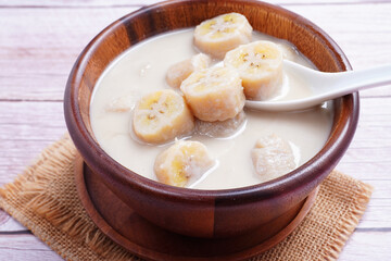 Banana in coconut milk, on a wooden cup of Thai dessert