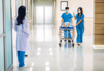 Group of professional medical doctor team and assistant with stethoscope in uniform taking seriously injured patient to operation emergency theatre room in hospital.health medical care concept