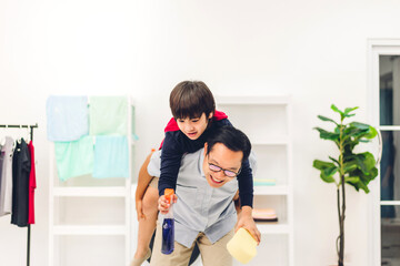 Portrait of enjoy happy love asian family father carrying little asian boy son on back smiling playing and having fun moments good time at home