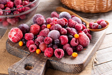 Mix of different frozen berries on a cutting board on table. Frozen Food. Food storage