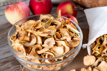 Dried apple slices in a bowl on wooden background