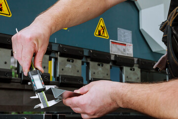 Accurate measurement of metal parts in the workplace near the bending machine with a caliper.