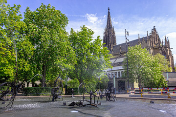 Playful trick fountains at Fasnachtsbrunnen (carnival fountain), also called Tinguely Brunnen (Tinguely fountain) with the Elisabethenkirche (Elisabethen church) in Basel, Switzerland