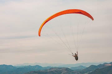Freedom is seen in the figure of a paraglider flying in the sky from the top of the mountain