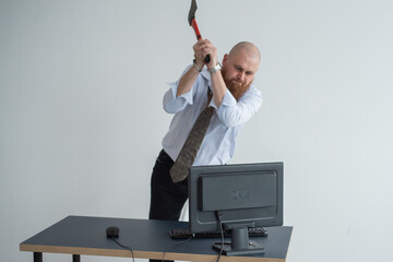 Stressed crazy businessman smashing his computer in office using ax problem concept. The man has...