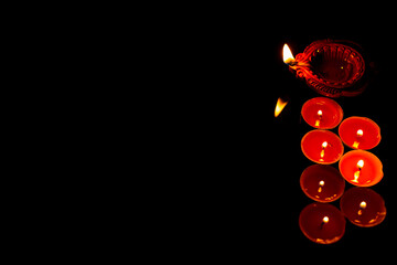 Happy Diwali. Clay diya lamps and aluminium cup candle lit during diwali celebration with copy space. Light festival of India.