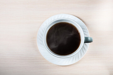 Obraz na płótnie Canvas A white ceramic cup with black coffee with smoke