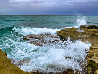 waves crash onto rocky shore on the beach