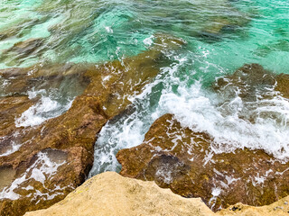 waves crash onto rocky shore on the beach