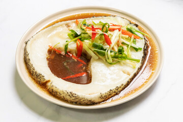 Steamed snow fish with soy sauce. Snow fish, soy sauce, ginger, scallion and chili. Top view on white table background.