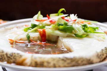Steamed snow fish with soy sauce. Snow fish, soy sauce, ginger, scallion and chili. Top view on white table background.