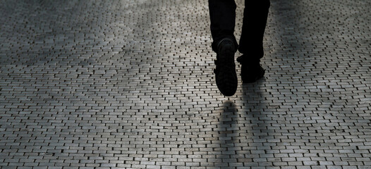 Silhouette or shadow of a man walking down the street one evening.