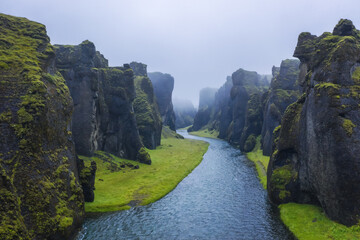 The famous and unique Fjadrargljufur valley in Iceland on a rainy day. Mossy cliffs and mountain...