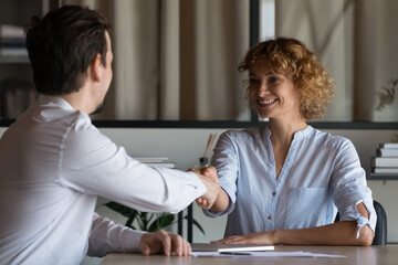 Happy female boss shaking hands with employee, hiring job candidate after interview. Businesswoman, Business leader finishing negotiation with handshake, Client thanking lawyer for legal expertise