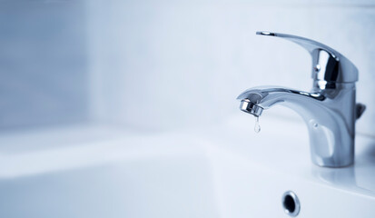 Water tap, stainless steel faucet. Drop drip in bathroom with sink. Liquid leak in modern clean house interior. Resources consumption concept.