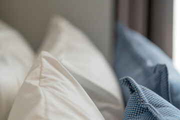 Bed maid-up with clean white pillows and bed sheets in beauty room. Close-up. Lens flair in sunlight.