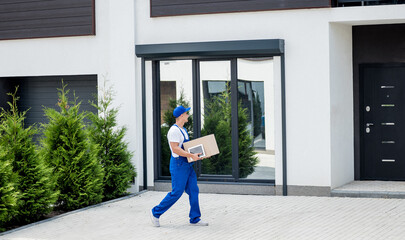 Young delivery man hold a cardboard box in his hands