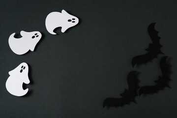 Handmade kids craft paper ghost and bat halloween party on black background