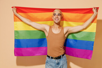 Young activist minded smiling fun blond latin gay man 20s with make up in beige tank shirt hold...