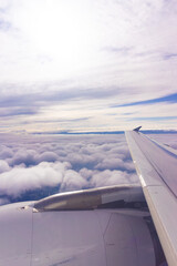 Fototapeta na wymiar Plane wing with a cloudscape below