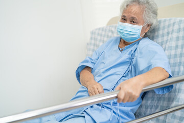 Fototapeta premium Asian senior or elderly old woman patient lie down handle the rail bed with hope on a bed in the hospital.