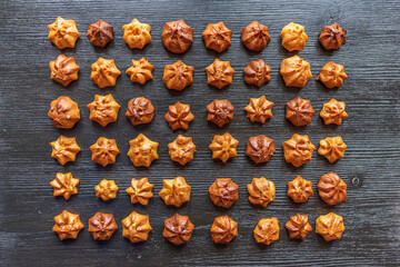 Delicious homemade organic eclairs laid out in a row on a wooden surface.