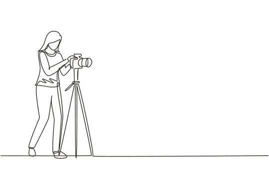 Continuous one line drawing female photographer taking photos using professional equipment set. Woman with camera making pictures. Studio photo equipment. Single line draw design vector illustration