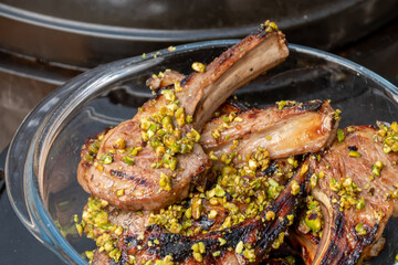 Lamb cutlets chops grilled on barbecue plate with pistachio nut . Backyard BBQ grill cooking. Australia Day celebration